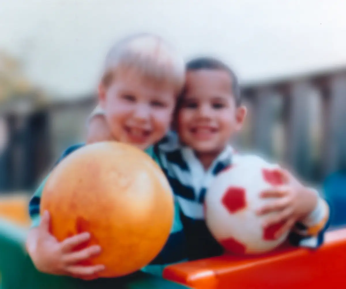 Two boys holding balls, seen out of focus and blurry